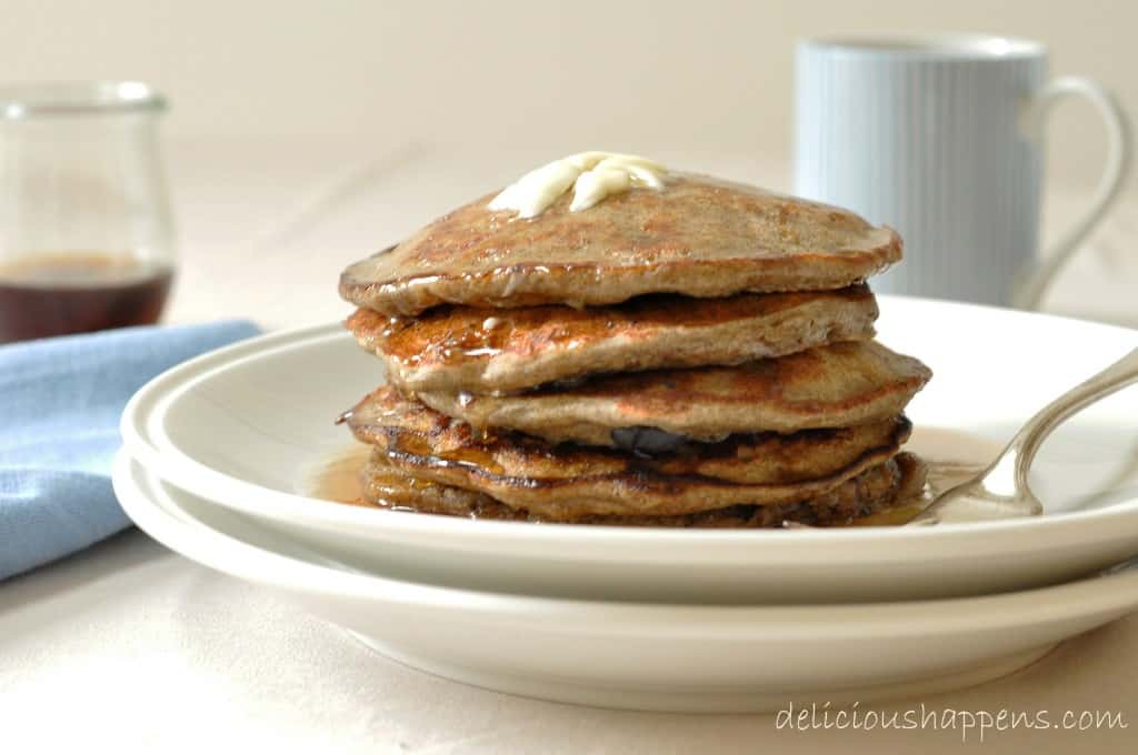 A white plate filled with a stack of flapjacks.