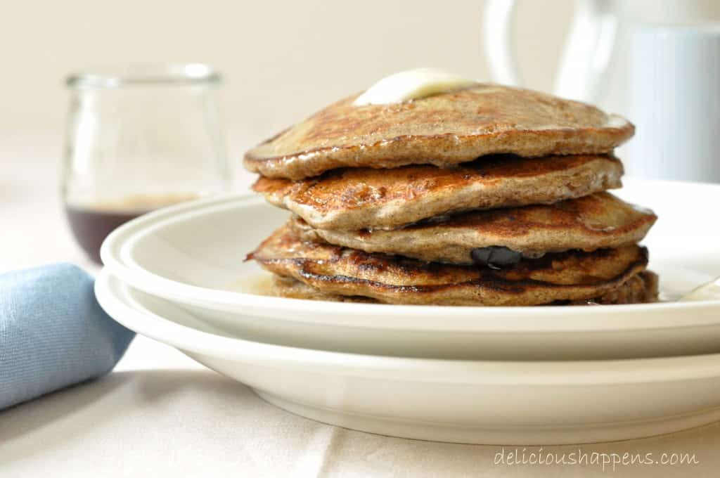 A white plate filled with a stack of Blueberry Banana Buckwheat Pancakes.