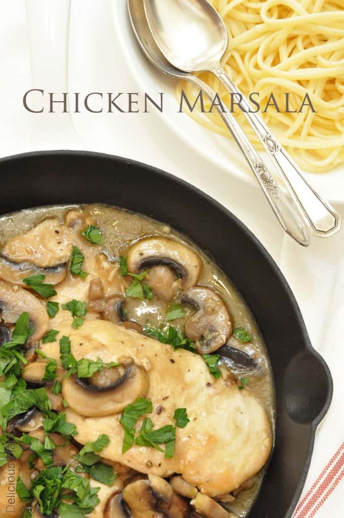 A black cast iron skillet filled with chicken marsala with mushrooms and sauce.