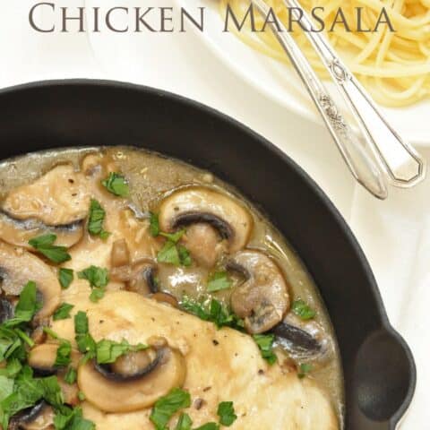 A black cast iron skillet filled with chicken marsala.