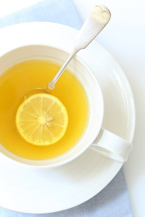 A white cup of lemon ginger turmeric tea.