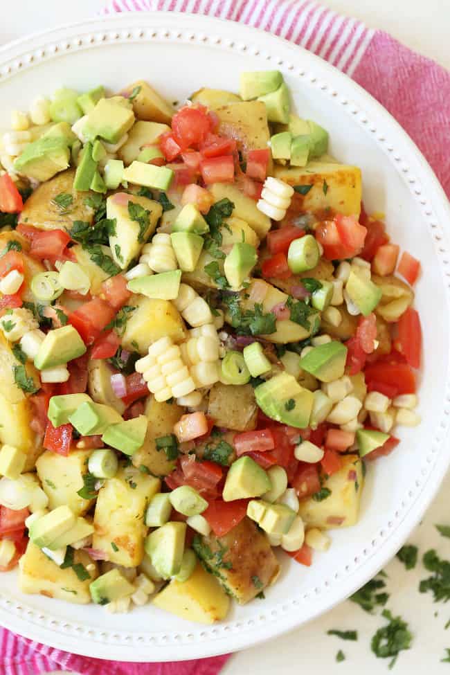 This Mexican Potato Salad is loaded with corn, tomatoes, avocado, green onion and cilantro all tossed in a cilantro lime vinaigrette