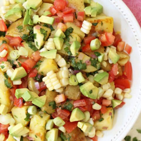 This Mexican Potato Salad is loaded with corn, tomatoes, avocado, green onion and cilantro all tossed in a cilantro lime vinaigrette