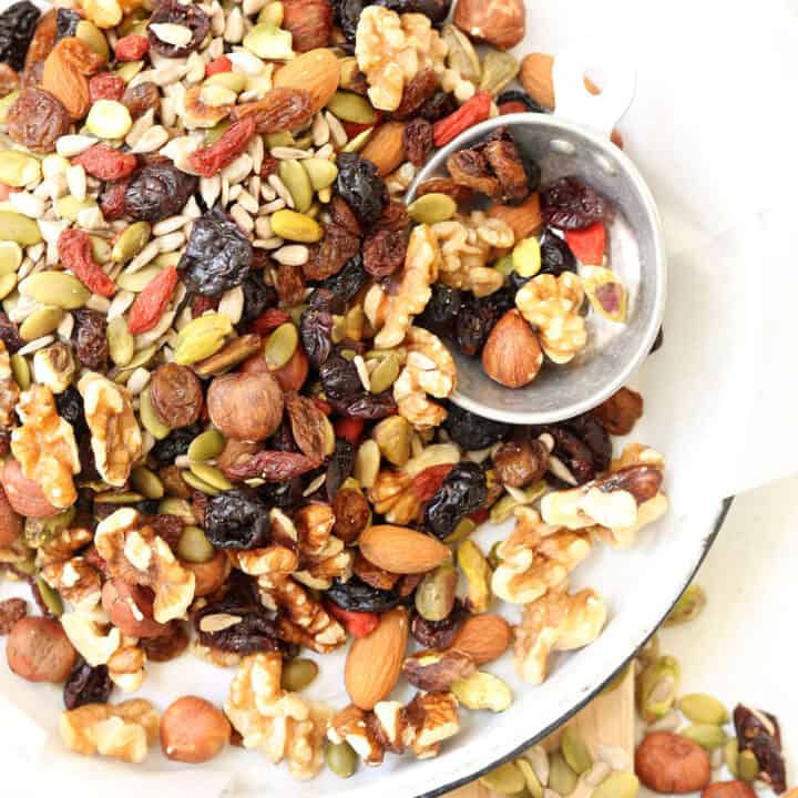 A round enamelware pie dish filled with trail mix.