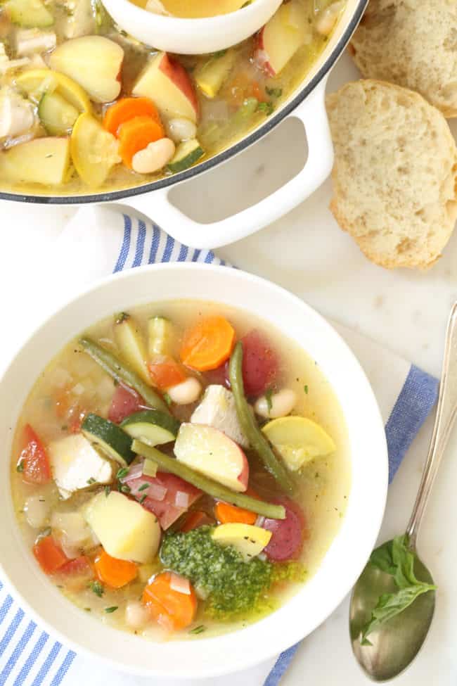 Soupe au pistou is a crowd-pleasing French vegetable soup loaded with zucchini, yellow squash and tomatoes, potatoes, beans, herbs and served with pesto