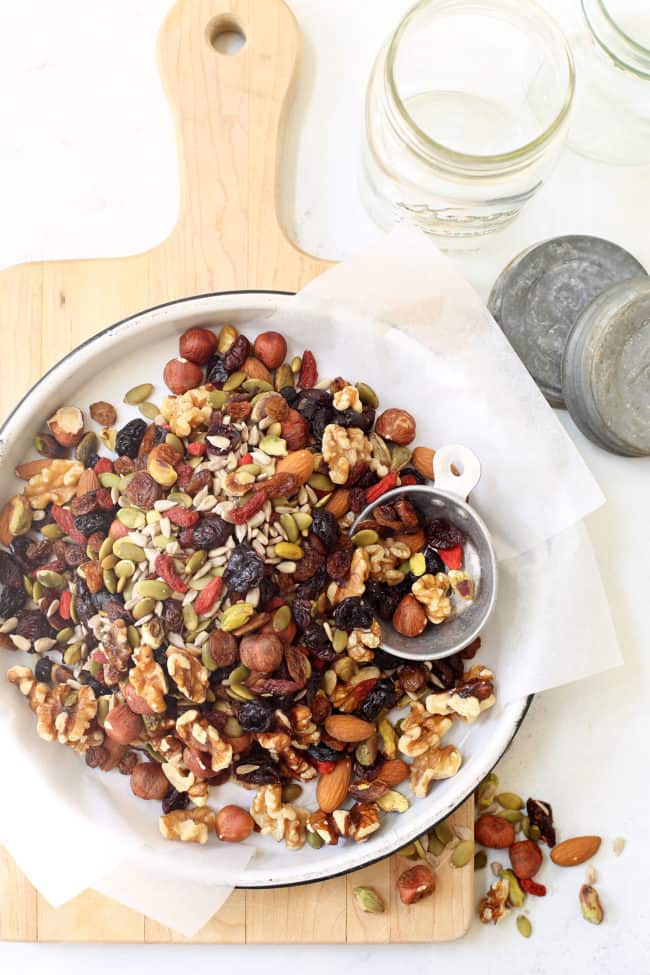 A round enamelware pie dish filled with trail mix.