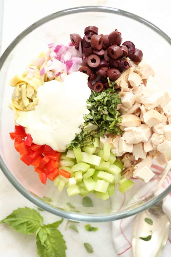 A clear mixing bowl filled with Italian Chicken Salad.