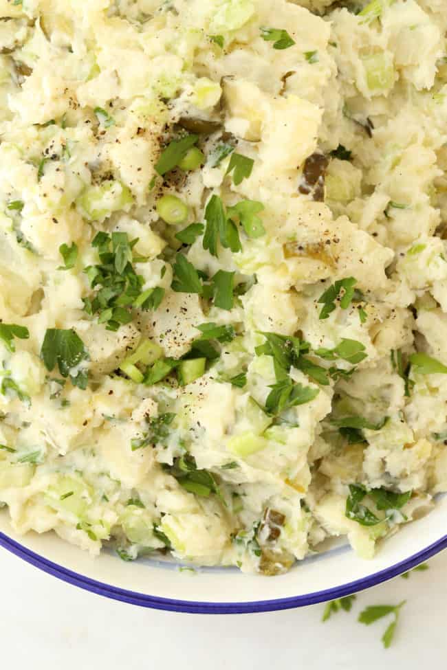 A white bowl filled with Dill Pickle Potato Salad.
