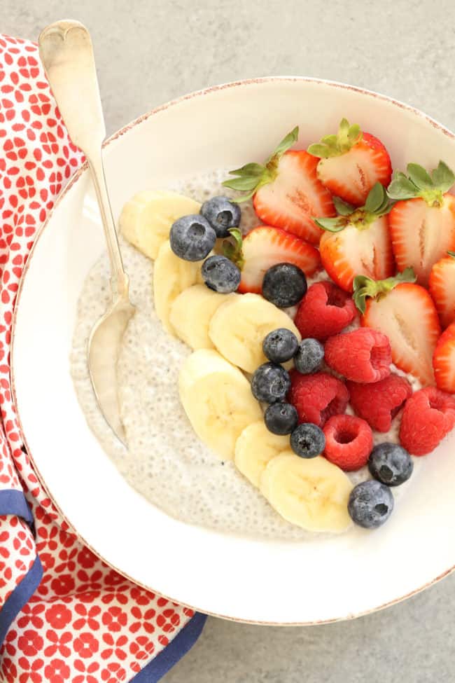 A white bowl filled with vanilla chia seed pudding and mixed fruit.