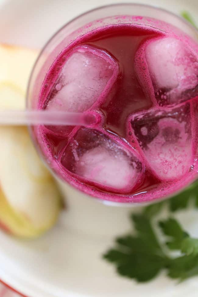 A clear glass filled with ice and juice.