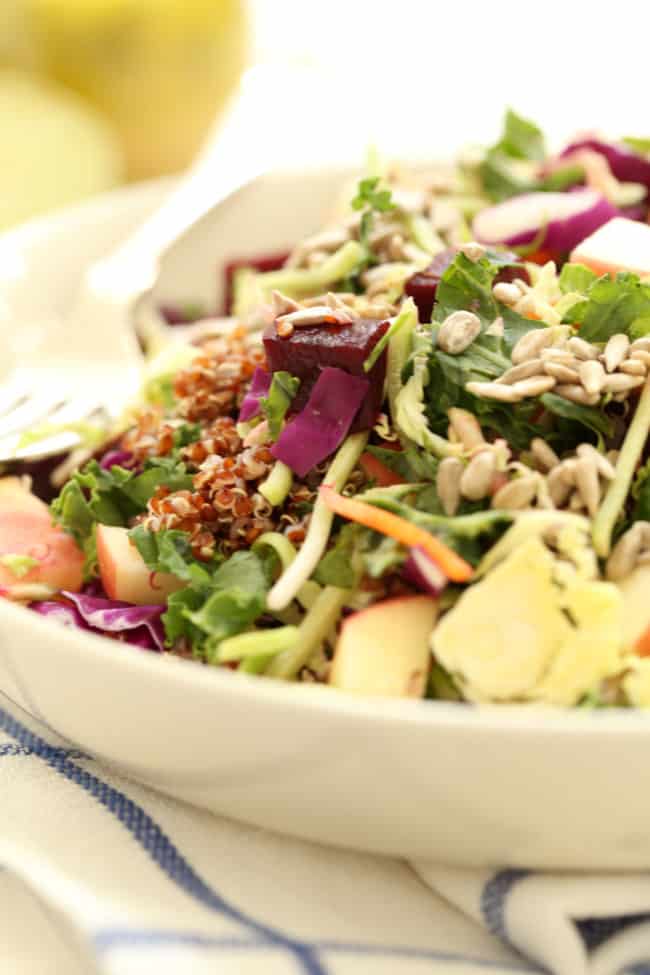 A white bowl of tossed kale superfood salad.