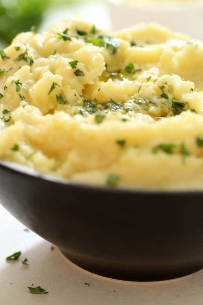 A dark brown bowl filled with a fluffy side dish. 
