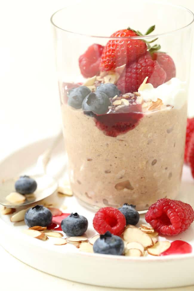 A clear glass jar filled with heart healthy breakfast of oatmeal and fruit