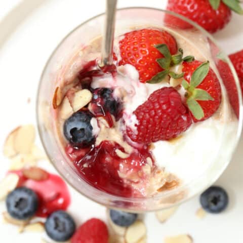 A clear glass jar of oatmeal with frui