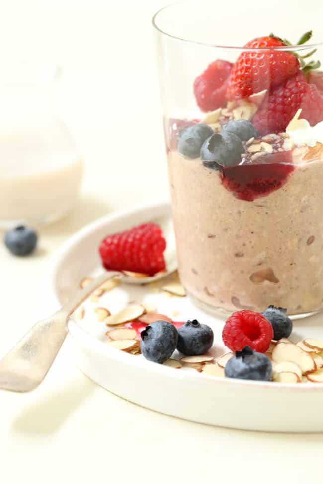 A clear glass filled with easy Greek yogurt overnight oats and fruit.