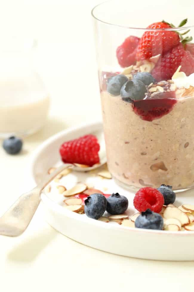 A clear glass filled with easy overnight oats and fruit.