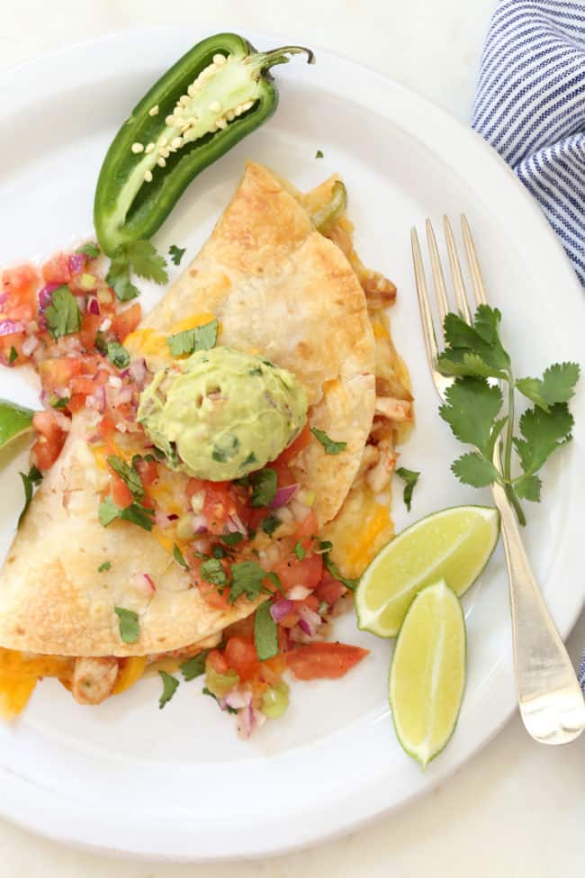  A white plate with a baked quesadilla on it.