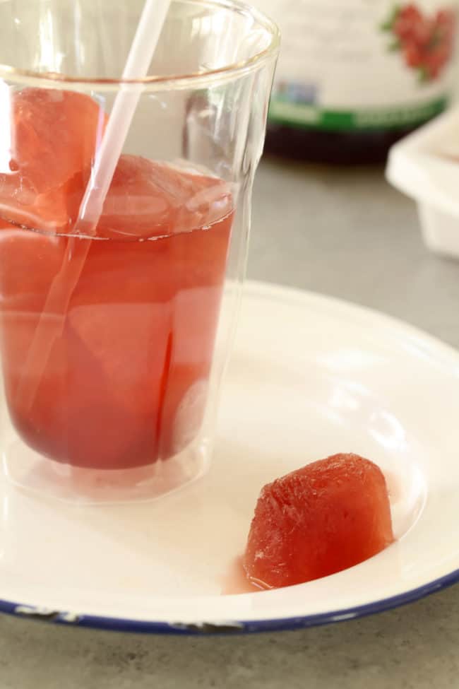 drinking glass filled with water and juice cubes