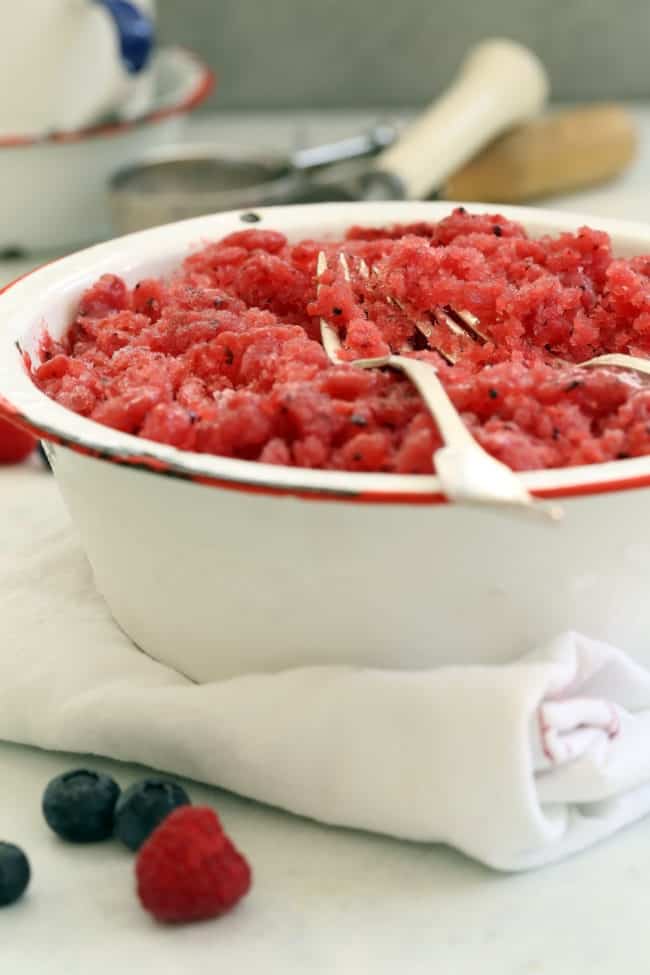 A white bowl filled with pink crushed ice. A fork rests in the bowl.