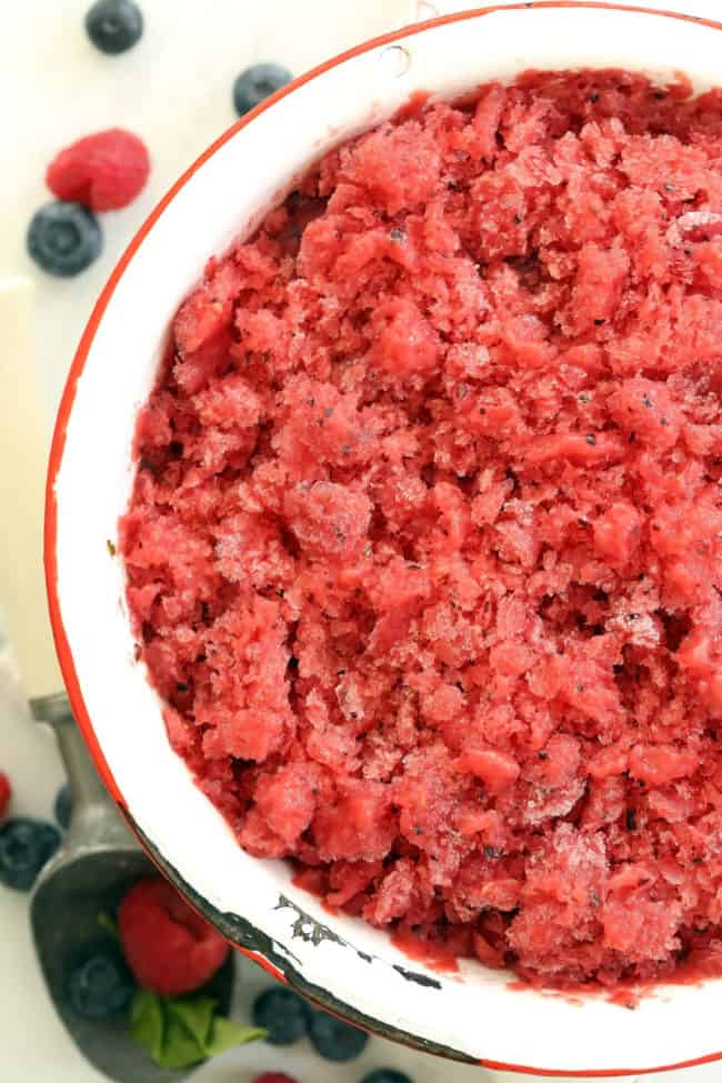 A white bowl filled with watermelon mixed berry granita.