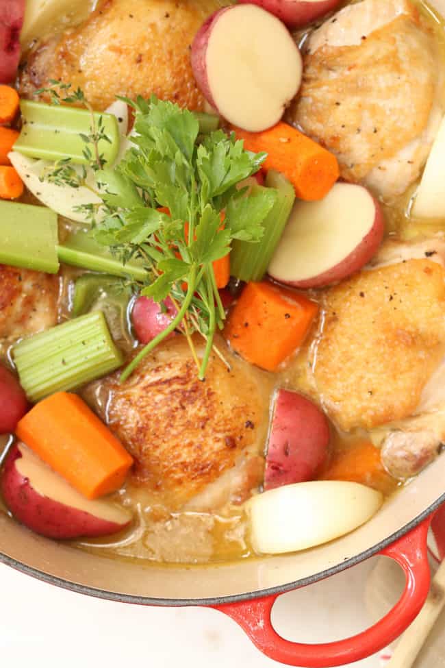 A large pot filled with cooked poultry and vegetables.