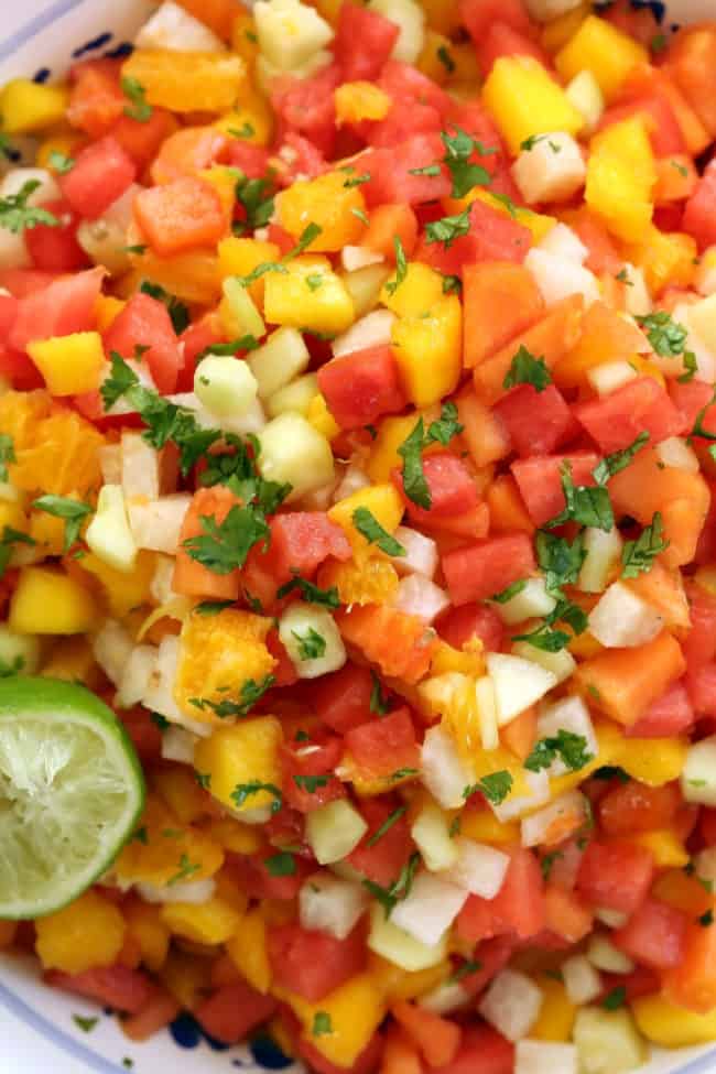 This Mexican Gazpacho Fruit Salad is a combination of watermelon, papaya, mango, jicama, cucumber and orange, and it's tossed in lime juice and sprinkled with chili powder