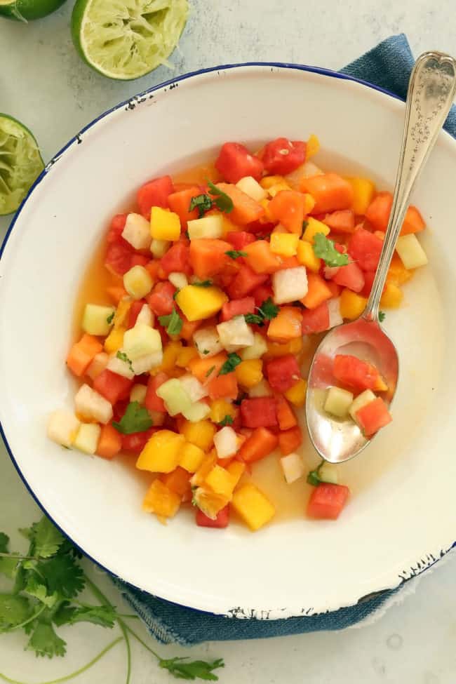 A white bowl of chopped Mexican style fruit salad.