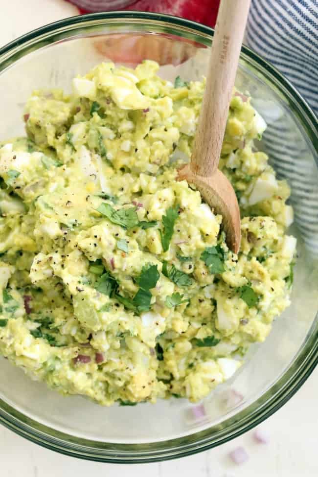 bowl of egg salad ingredients - mashed hard boiled eggs and avocado