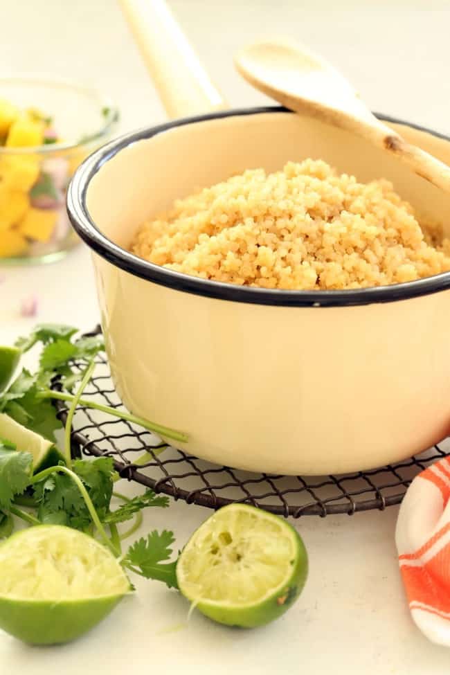 A white pot filled with a fluffy grain side dish.