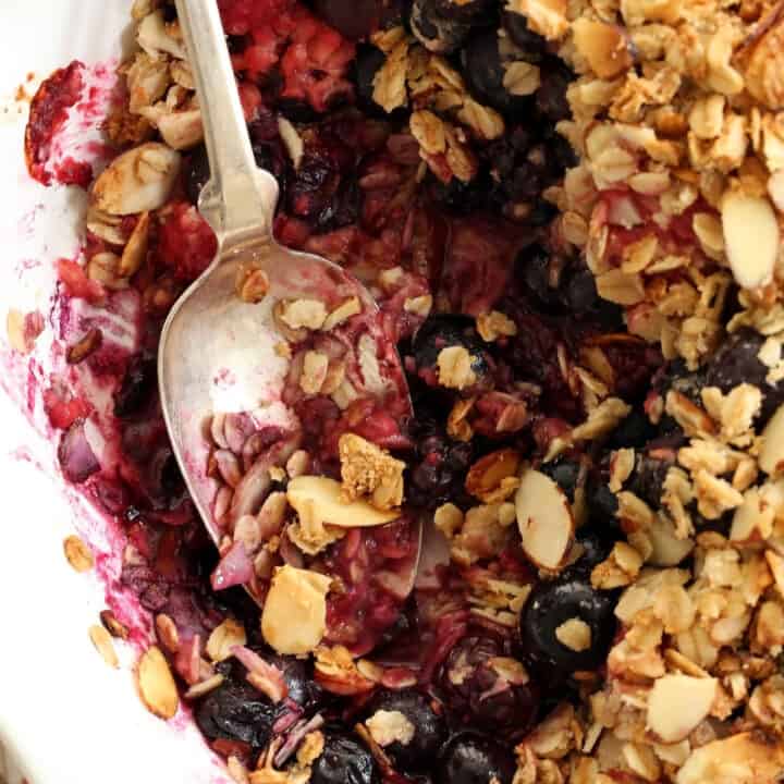 A white pie dish filled with mixed berry crisp