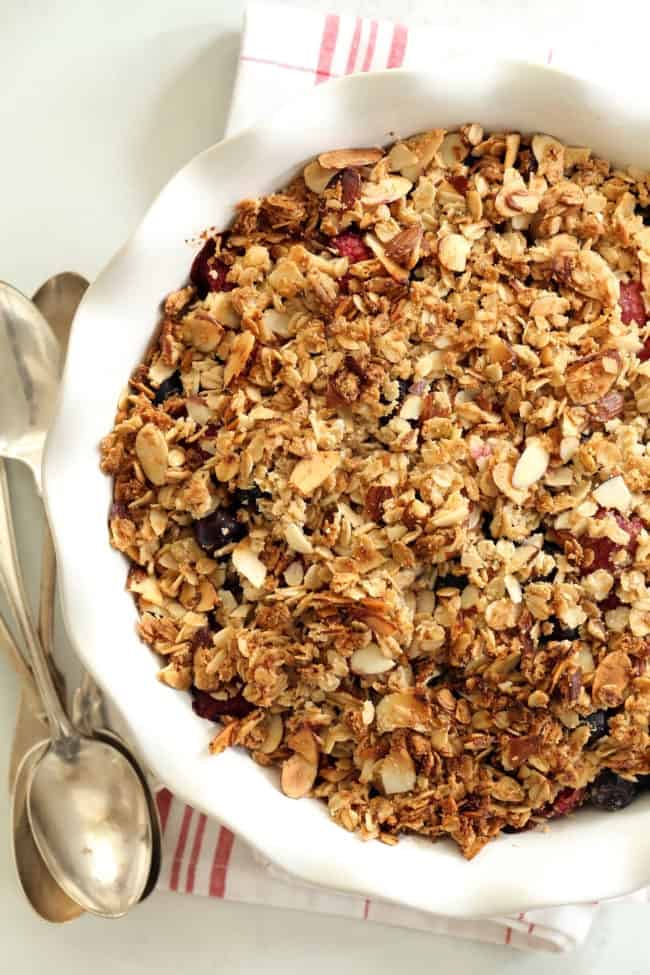 A white pie dish filled with mixed berry crisp