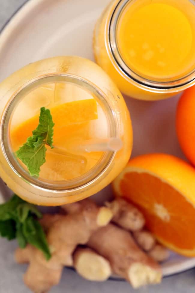 Two mason jars filled with iced orange ginger green tea