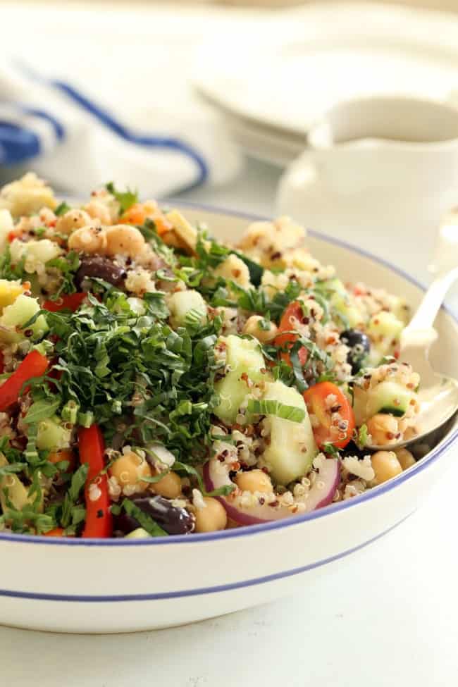 A large white bowl filled with a cold quinoa salad.