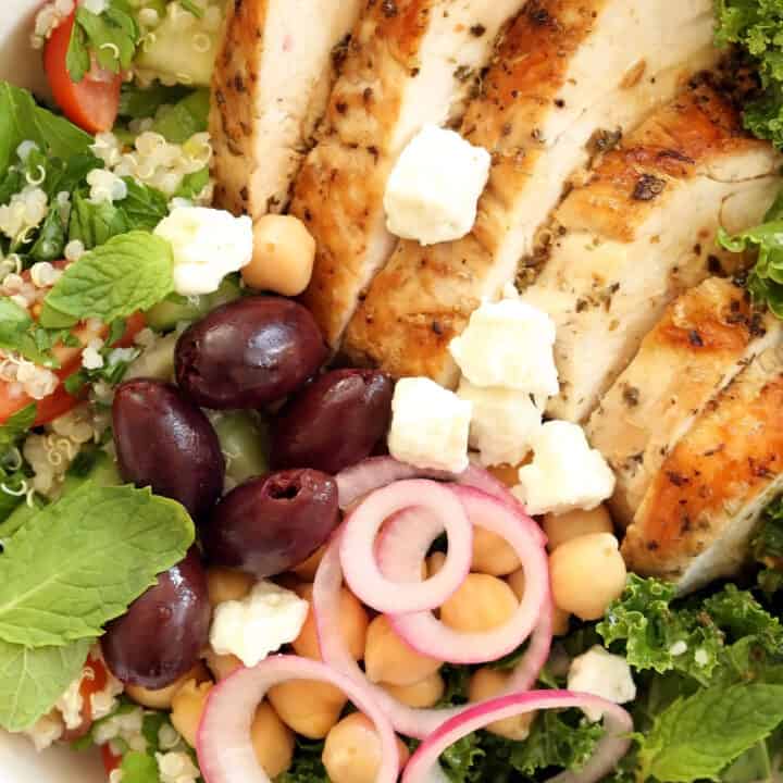 This Greek Chicken Bowl is made with marinated chicken breast, quinoa tabbouleh, kale, garbanzo beans, pickled onions, kalamata olives and feta cheese