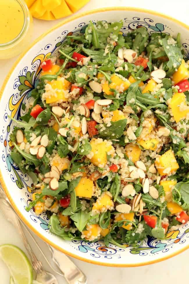 bowl of tossed mango arugula quinoa salad