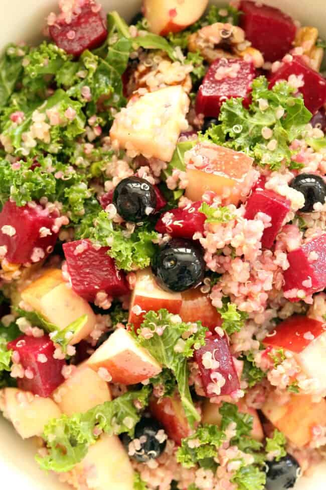 A white bowl filled with Beet Kale Quinoa Salad.