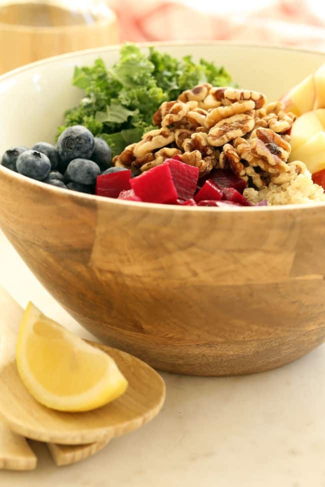 A wooden bowl filled with chopped fruits and vegetables.