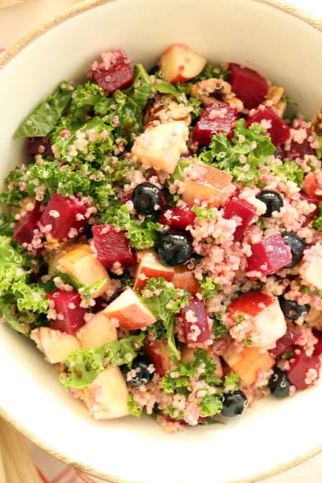 A white bowl of kale and quinoa salad.