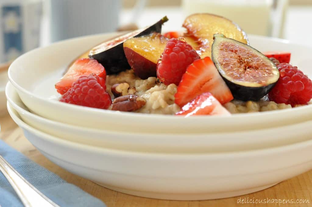 A white bowl filled with steel cut oatmeal and fruit