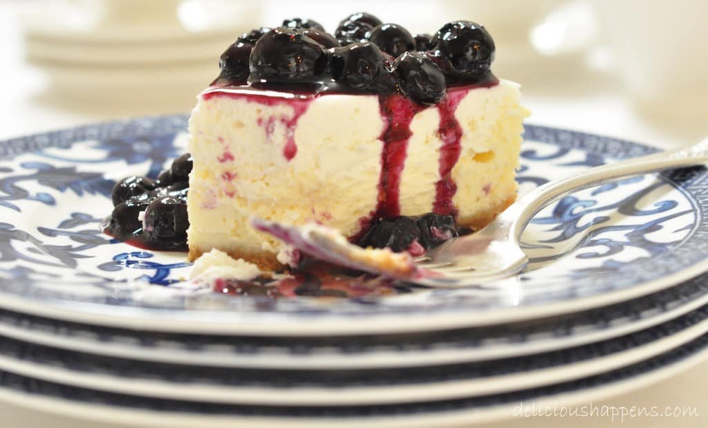 This two-layered Blueberry Cheesecake that's extra creamy with a delicate graham cracker crust and topped with a homemade blueberry sauce