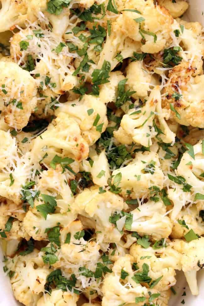 A roasting dish filled with roasted cauliflower topped with parmesan cheese