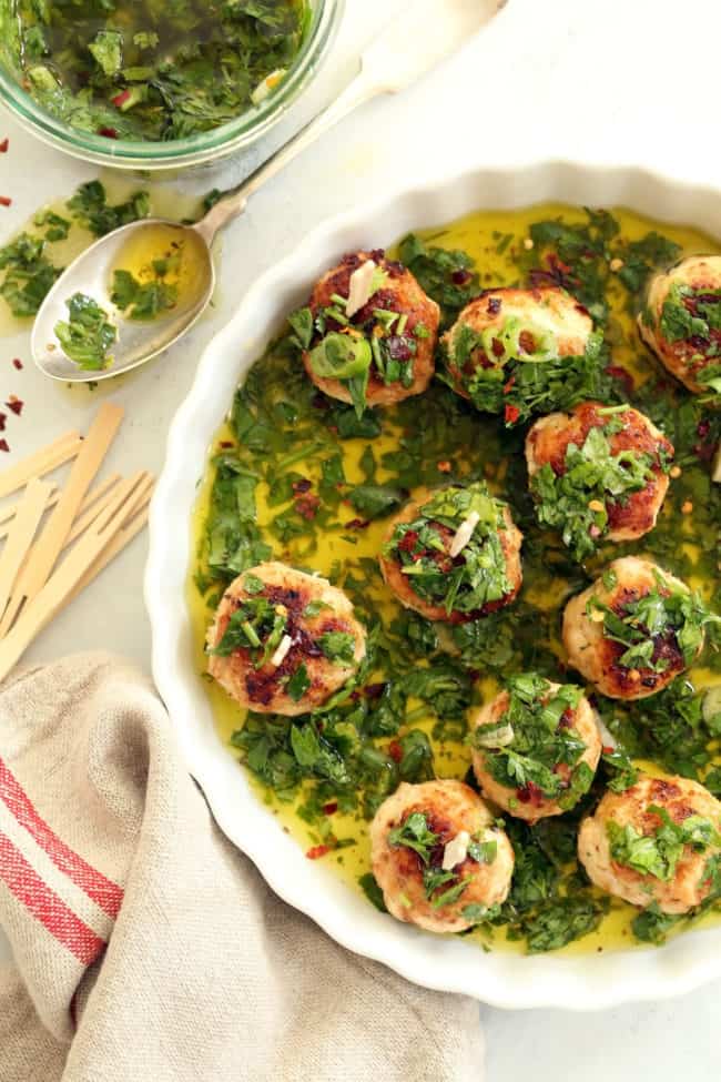 A white round shallow tray filled with chicken chimichurri cocktail meatballs.