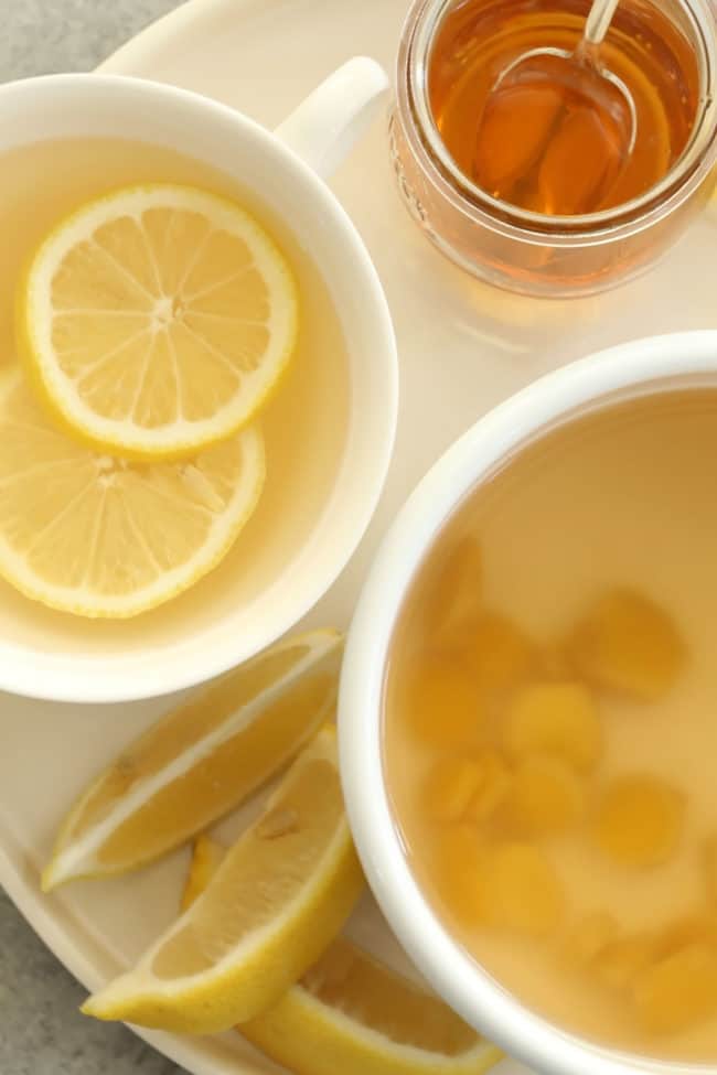 A white cup filled with water and lemon slices.