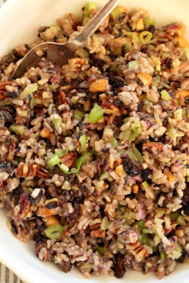 A white bowl filled with grains and vegetables.