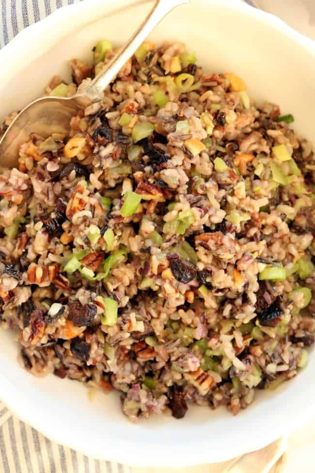 A white bowl filled with cooked grains and chopped vegetables.