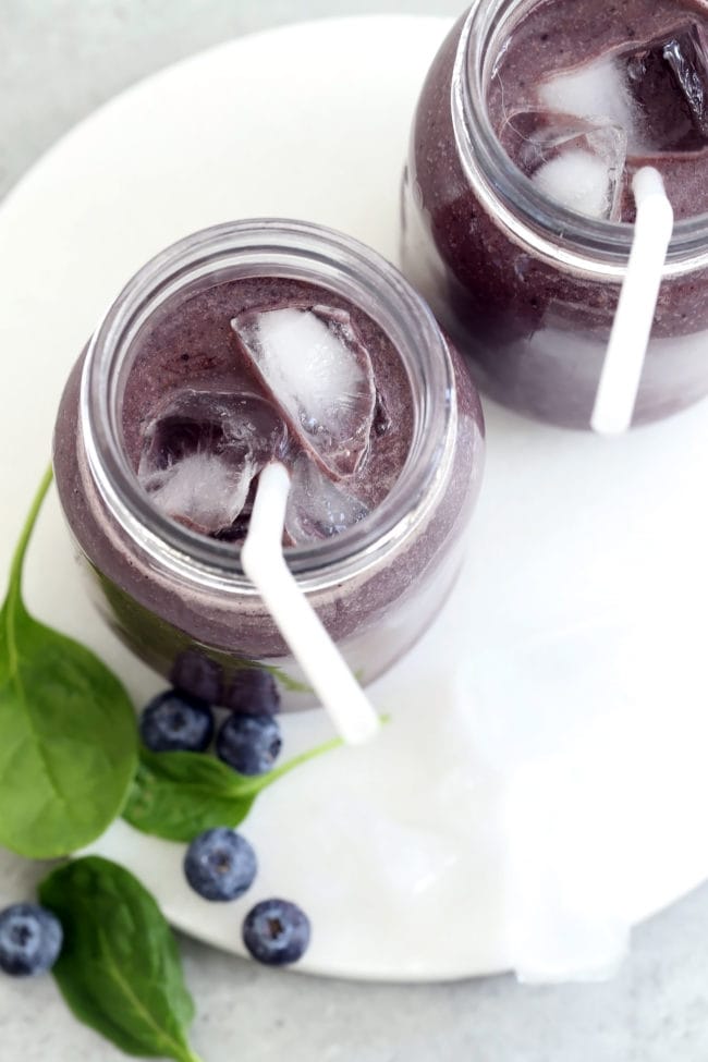 Two clear glasses filled with Blueberry banana smoothie.