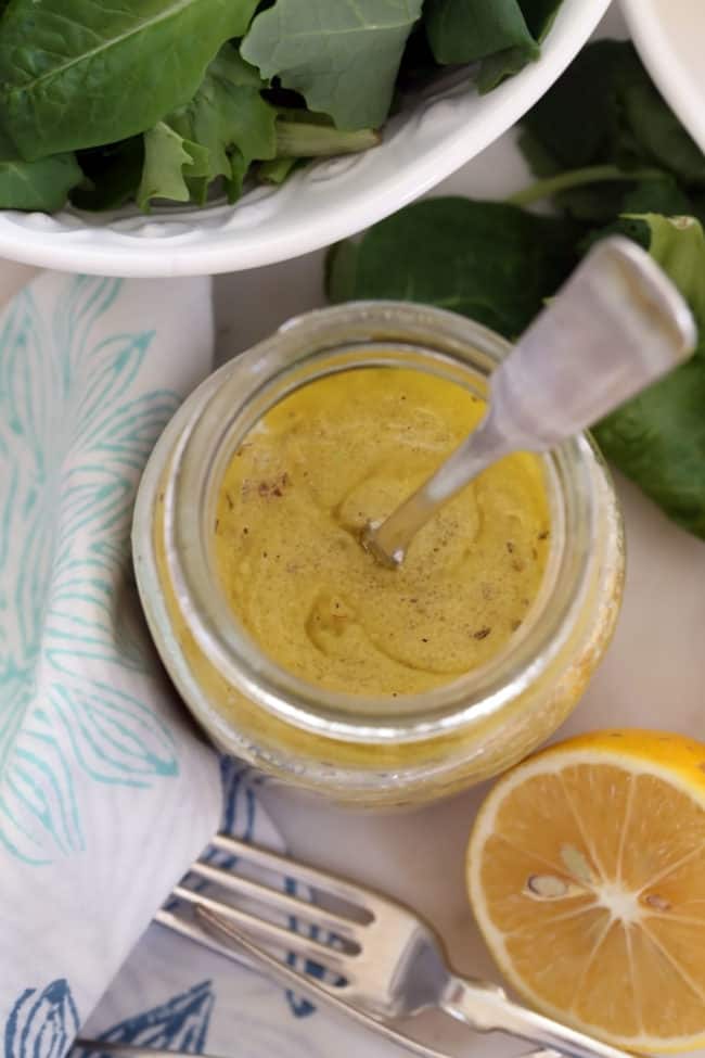 A glass mason jar half filled with salad dressing.