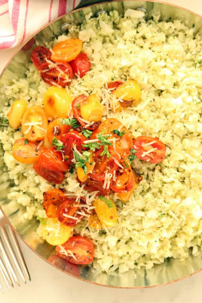 A skillet filled with Cauliflower Rice and roasted cherry tomatoes.