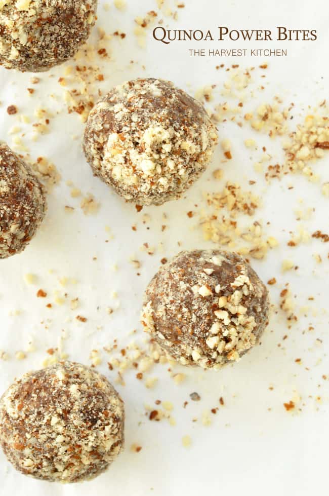 Five quinoa power bites on a white pastry board.