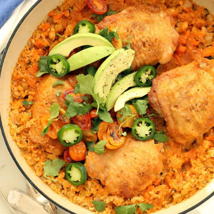A white skillet filled with chicken and cauliflower rice.